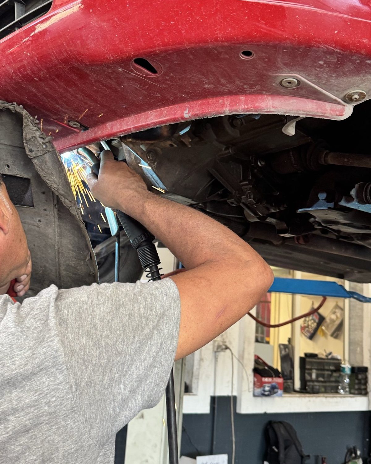 Lavori di meccanica sotto la scocca di un'auto nell'officina Bologna Pneumatici
