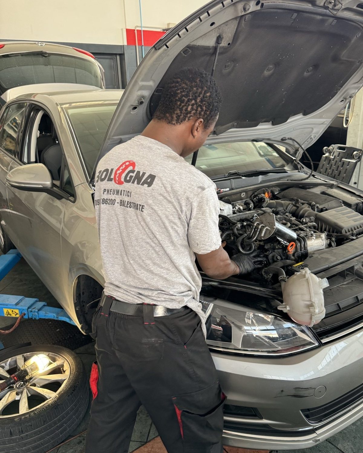 Meccanico Bologna Pneumatici al lavoro sul motore di un'auto
